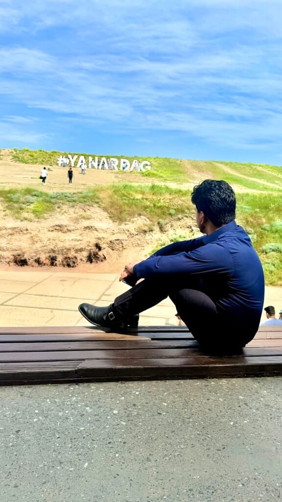 Saqib Jatoi sitting at Yanar Dag, Azerbaijan